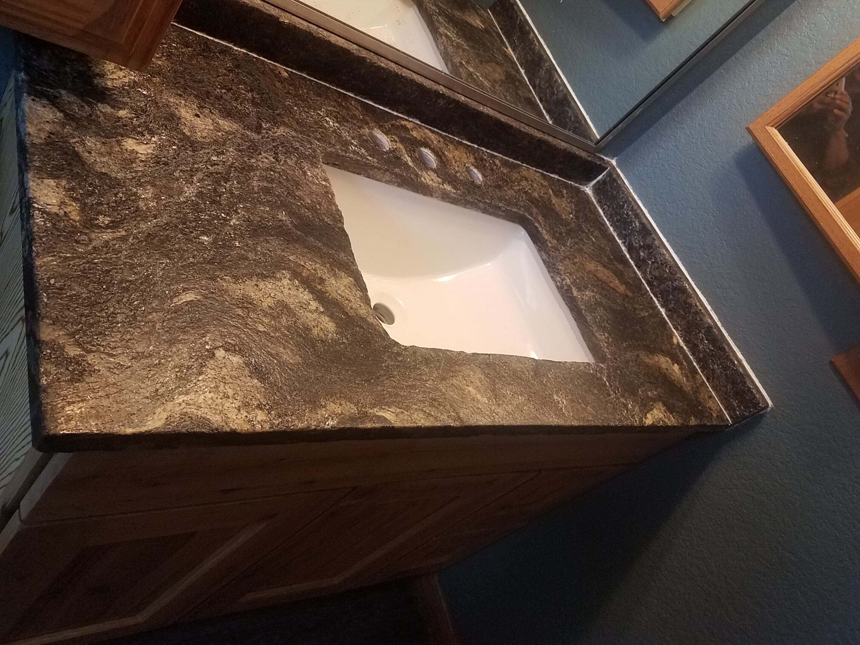 Bathroom sink with dark marble countertop.