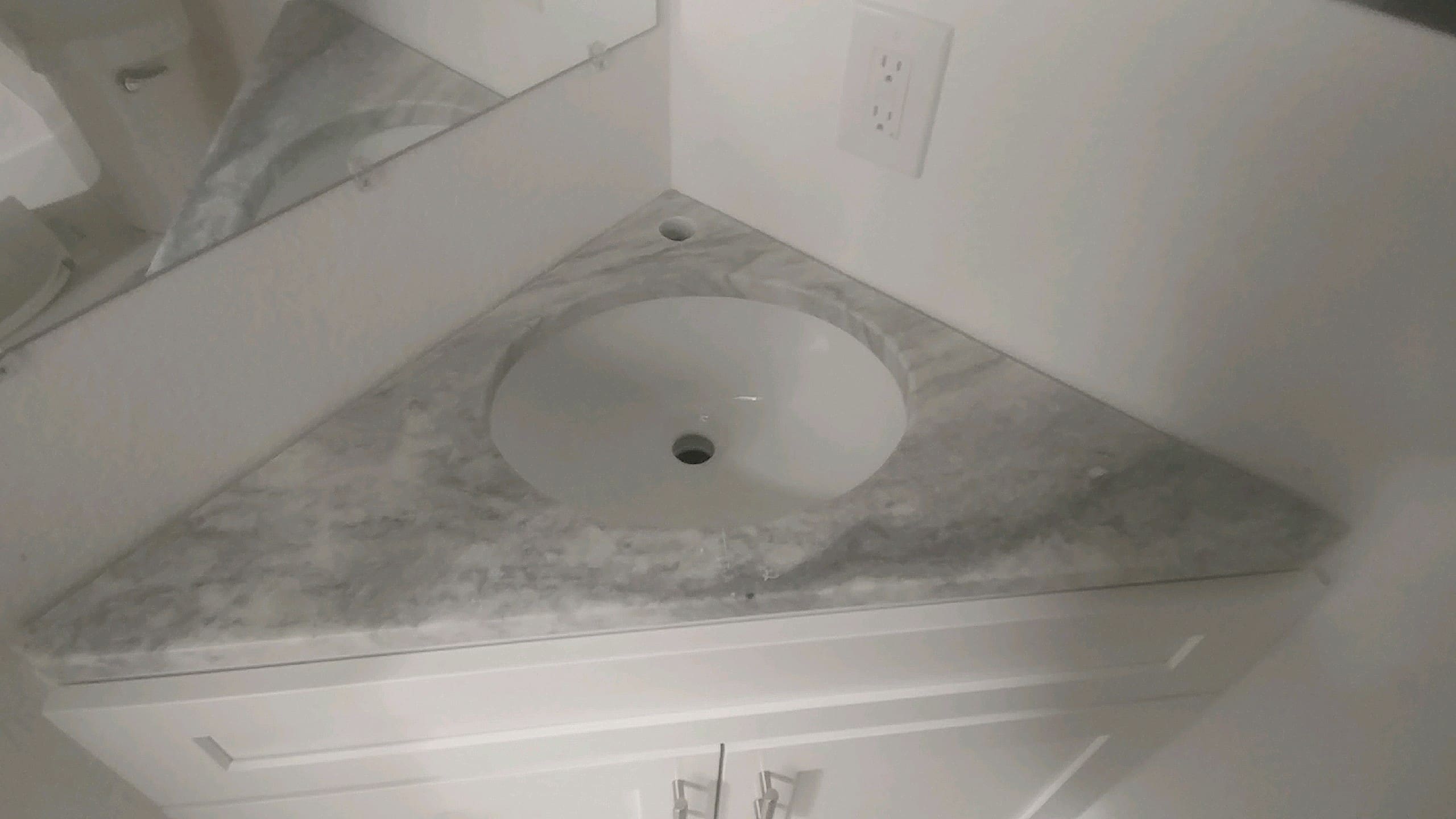 Corner sink with marble countertop.