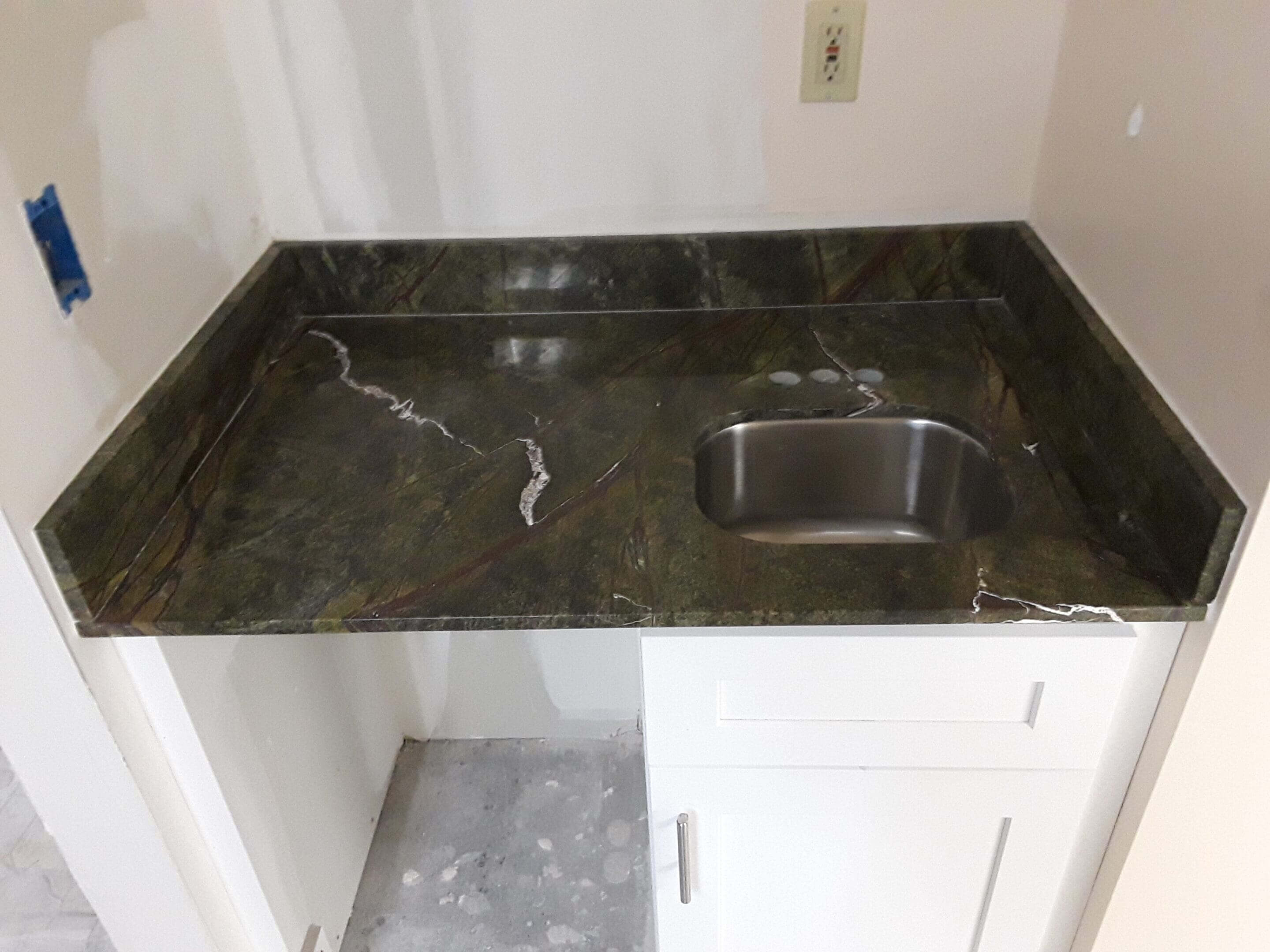Small countertop with sink and cabinet below.