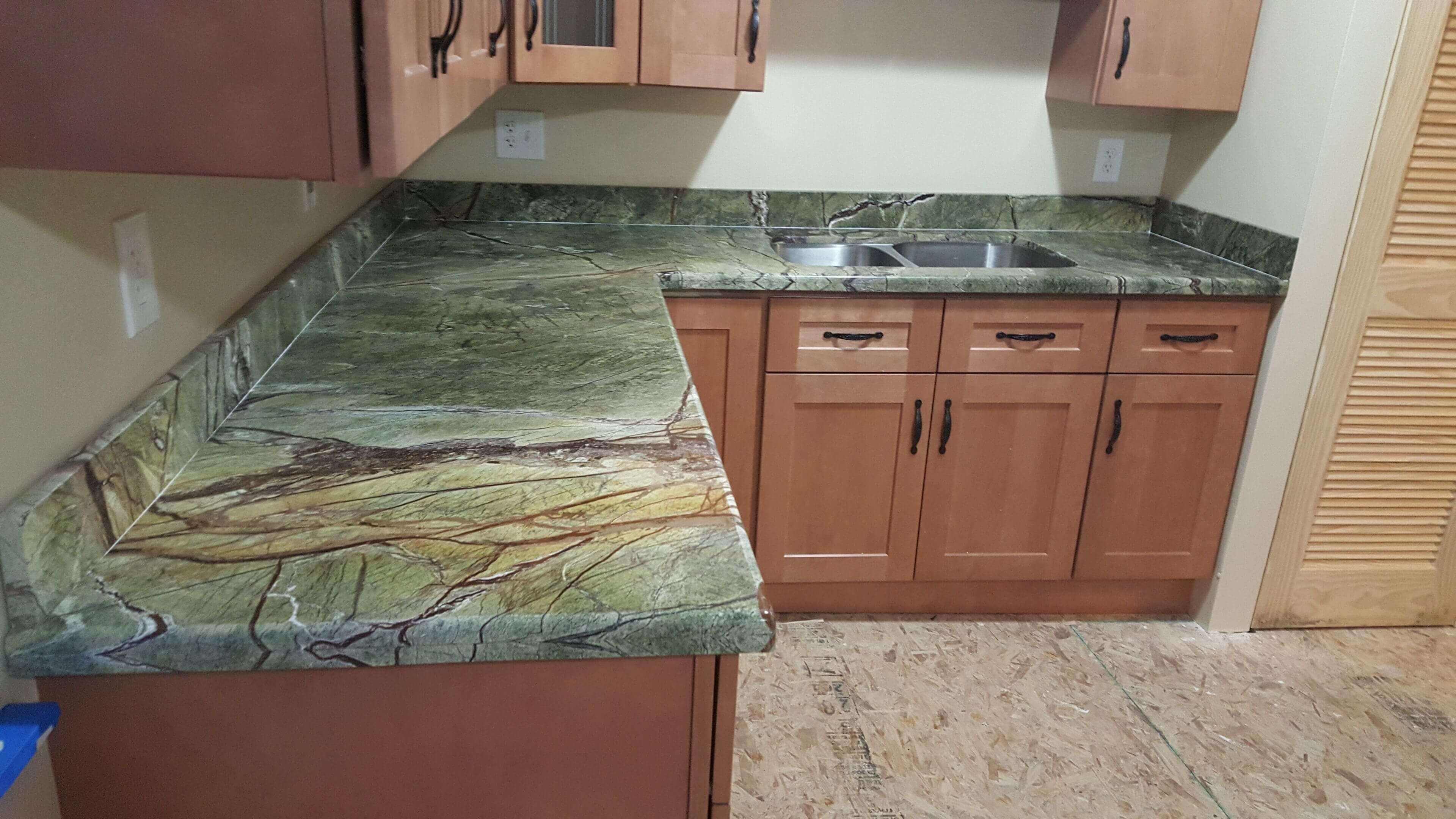 Kitchen with green marble countertops and cabinets.