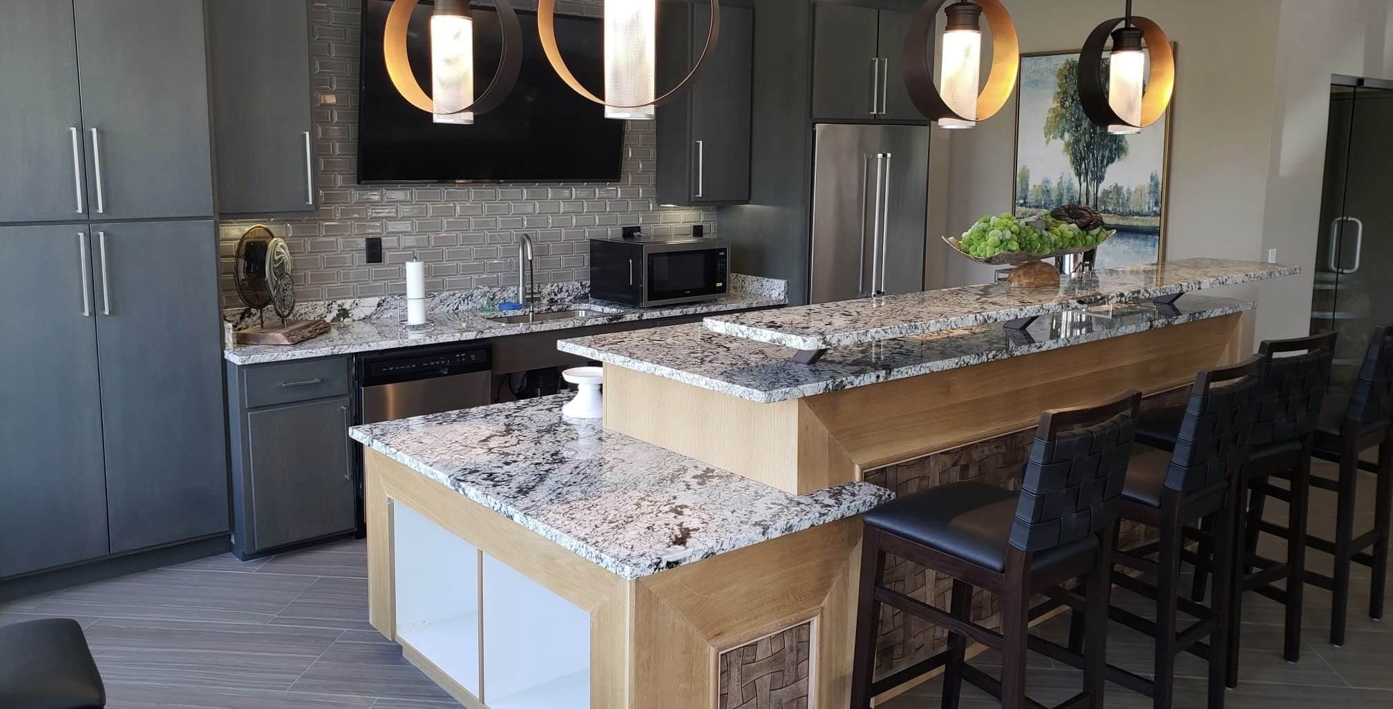 Modern kitchen with granite countertops and lighting.
