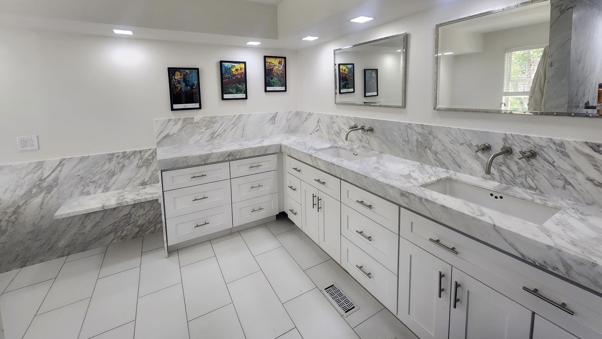 Modern white bathroom with marble countertops.