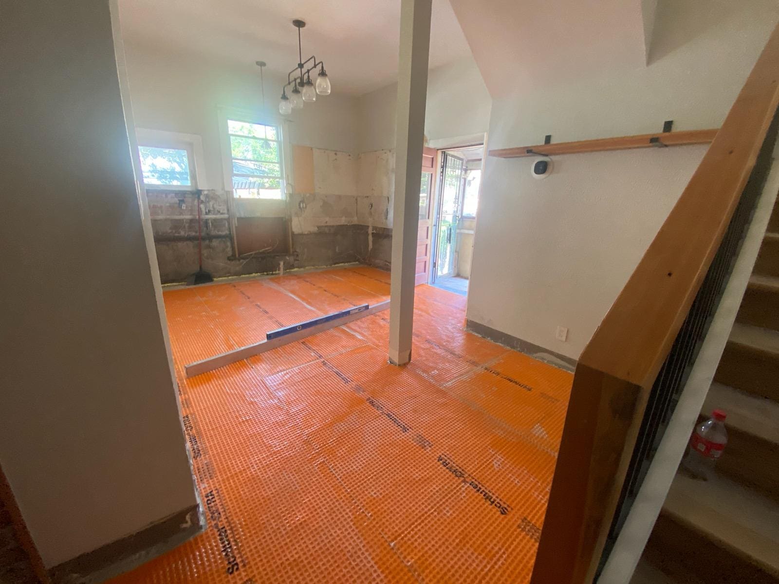 Room under renovation with orange floor mats.