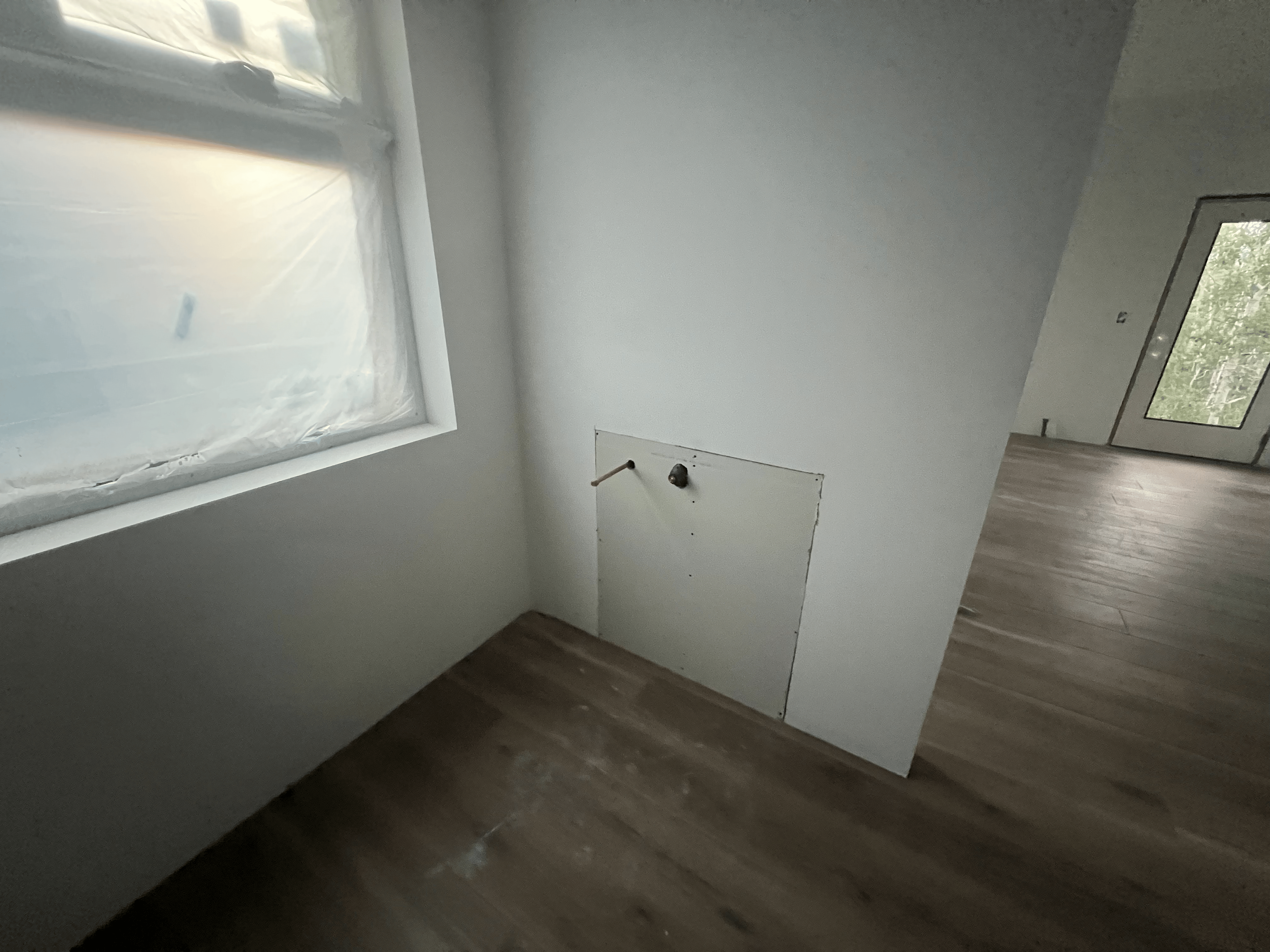 White room with small door and window.