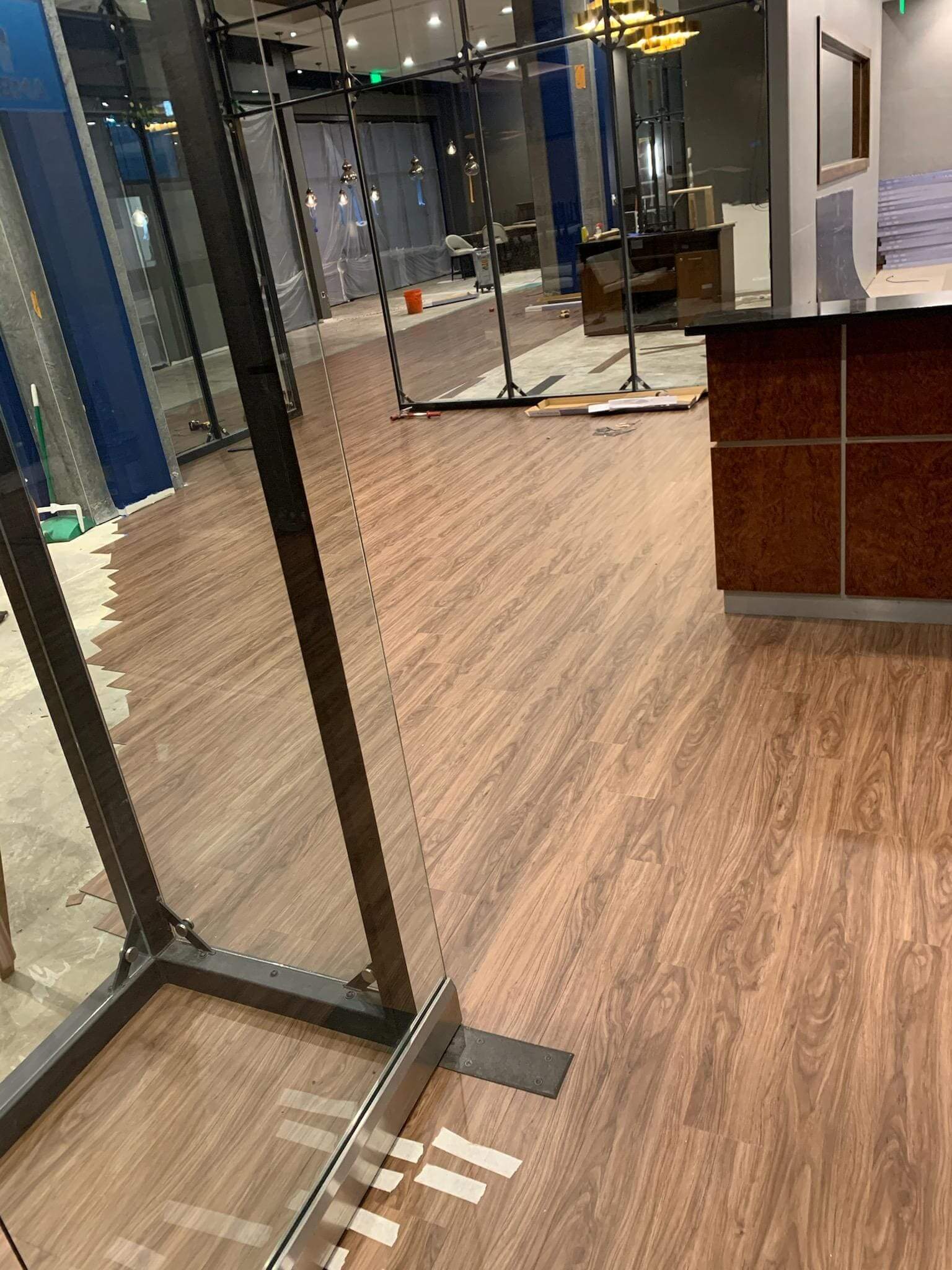 Office with wooden flooring and glass doors.