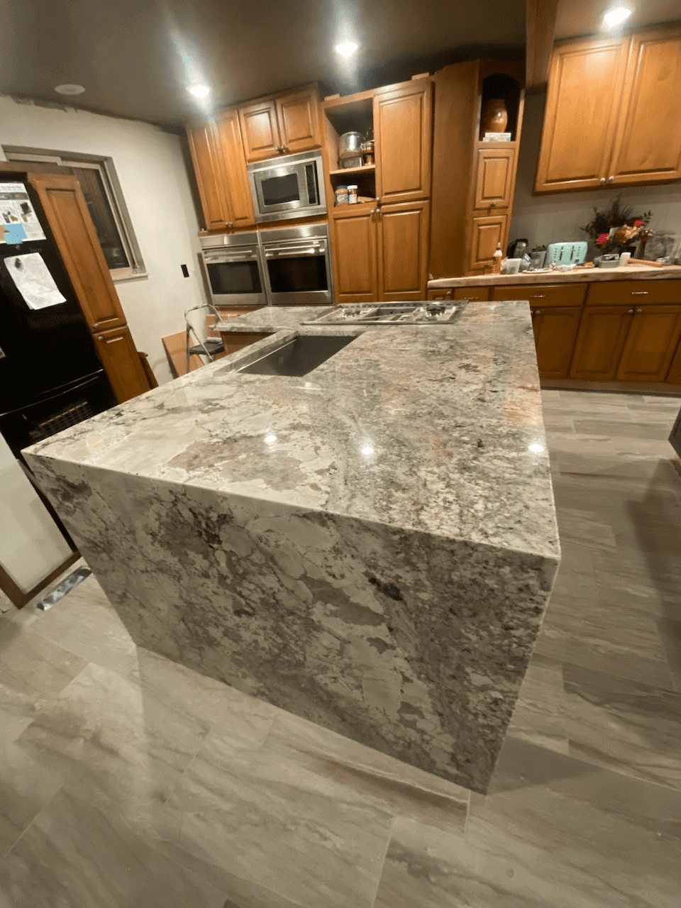 Modern kitchen with large marble island countertop.