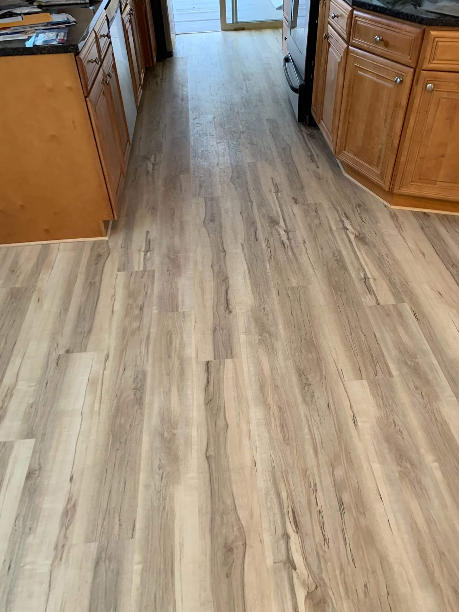 Wooden kitchen floor with light cabinets.