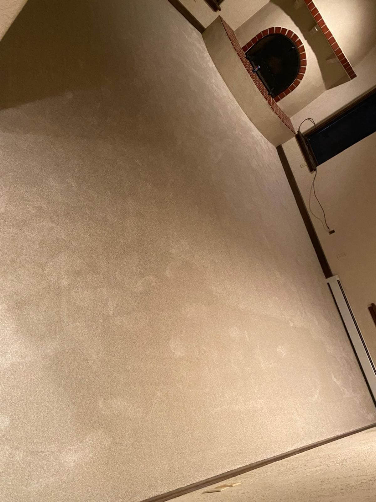 Room with beige wall and brick archway.