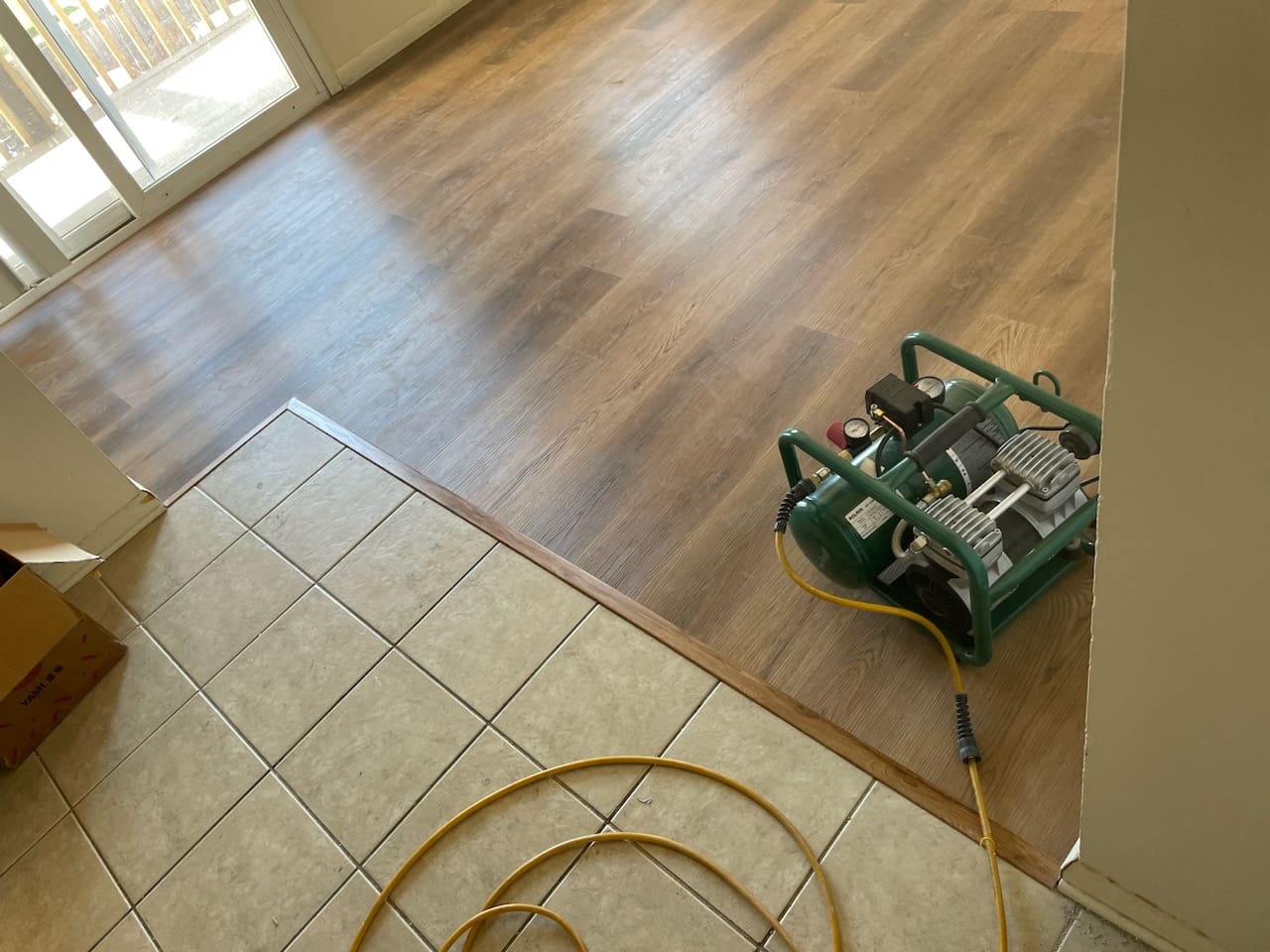 Flooring installation with tile and wood transition.