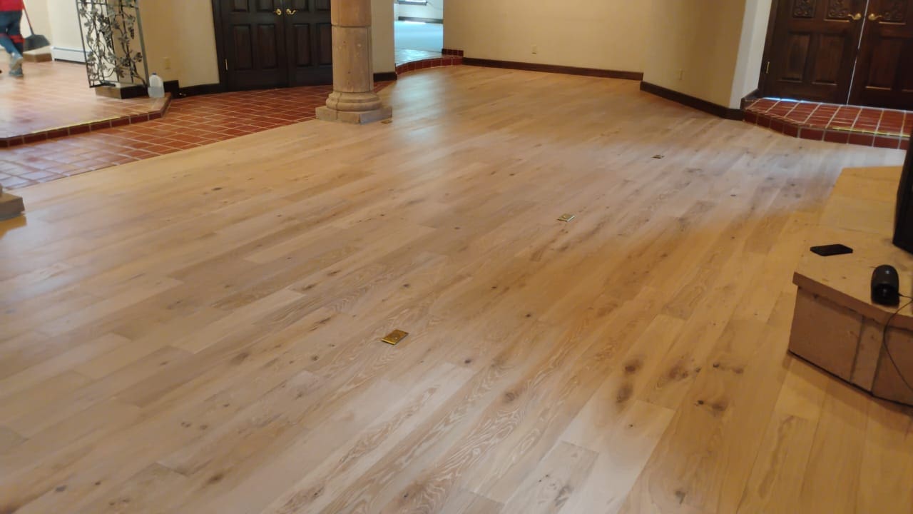 Spacious room with light wooden flooring.
