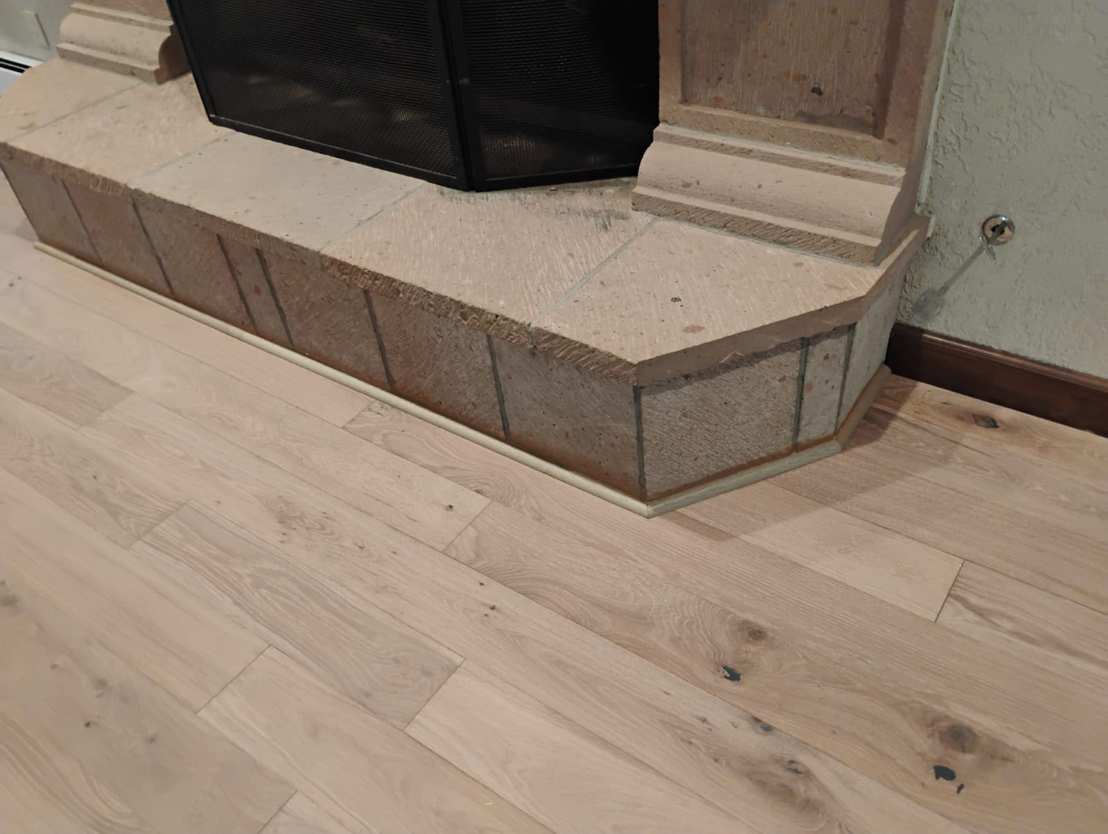 Fireplace with stone hearth and wooden floor.