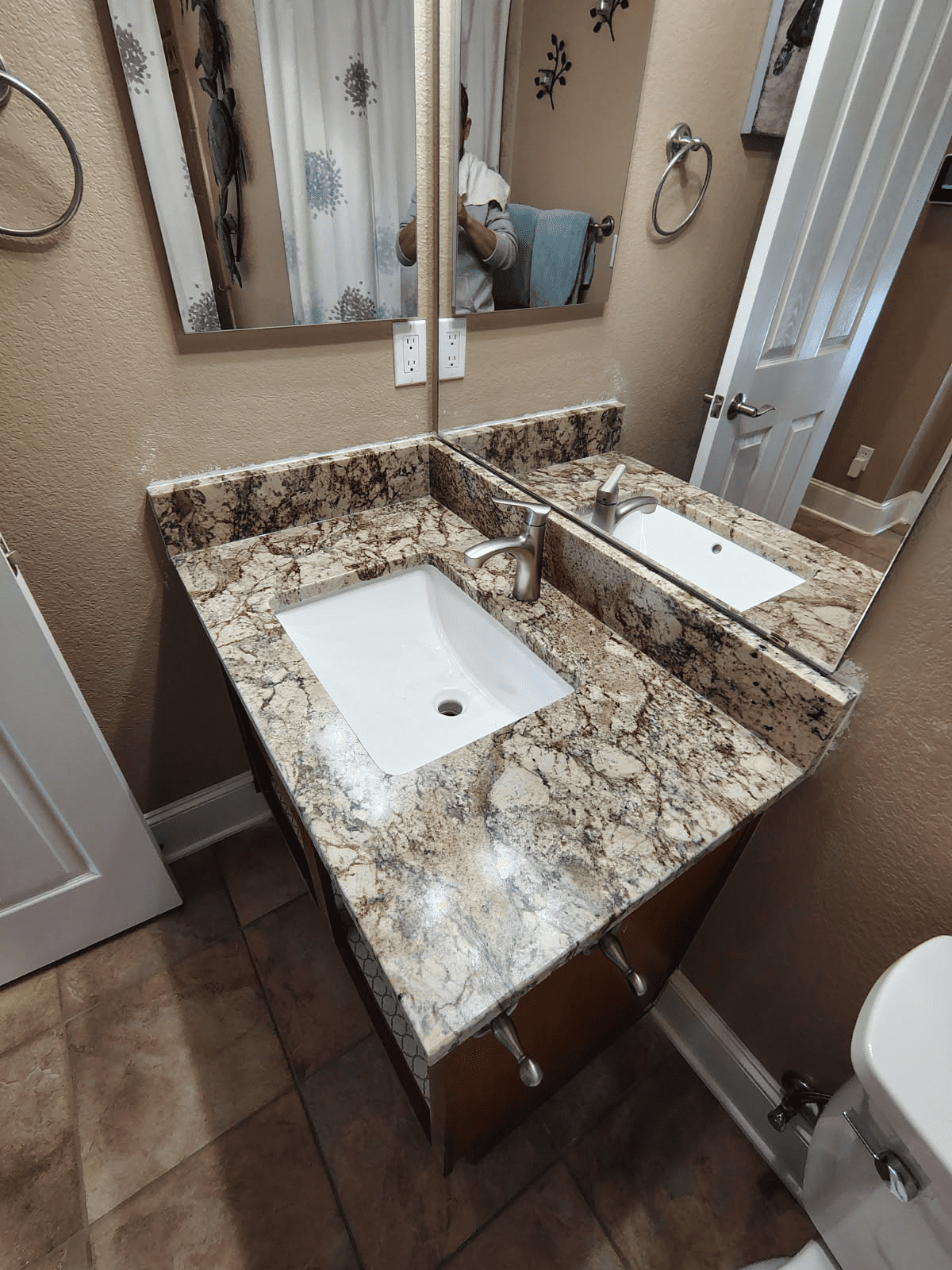 Bathroom with granite countertop and mirror.