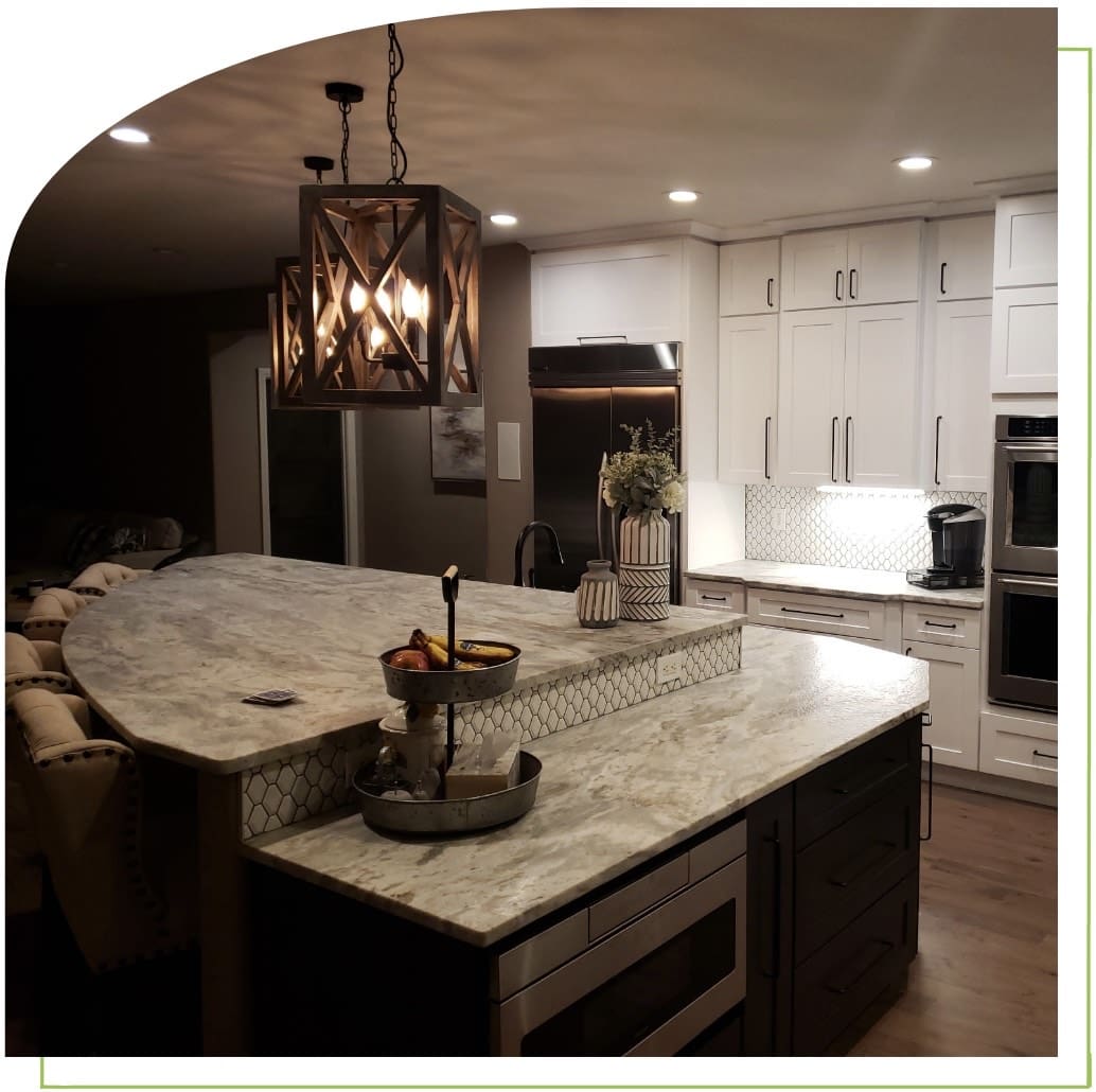 Modern kitchen with marble island and lighting.