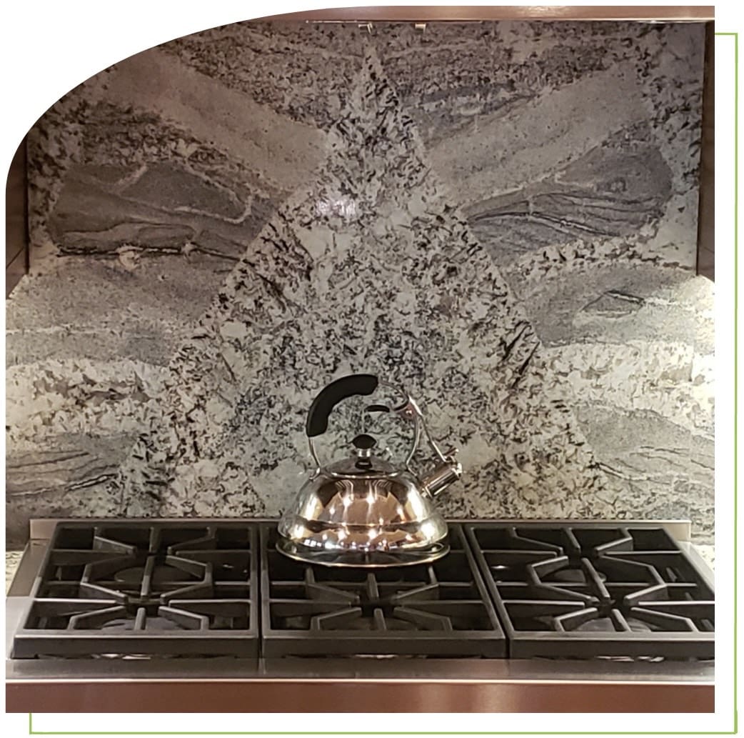 Stovetop with kettle and patterned backsplash.