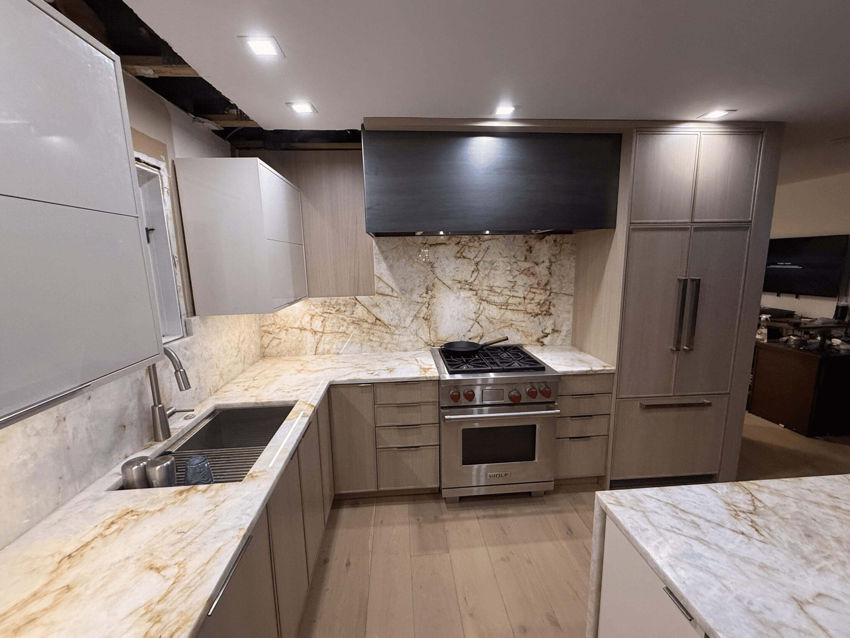 Modern kitchen with marble countertops and cabinets.