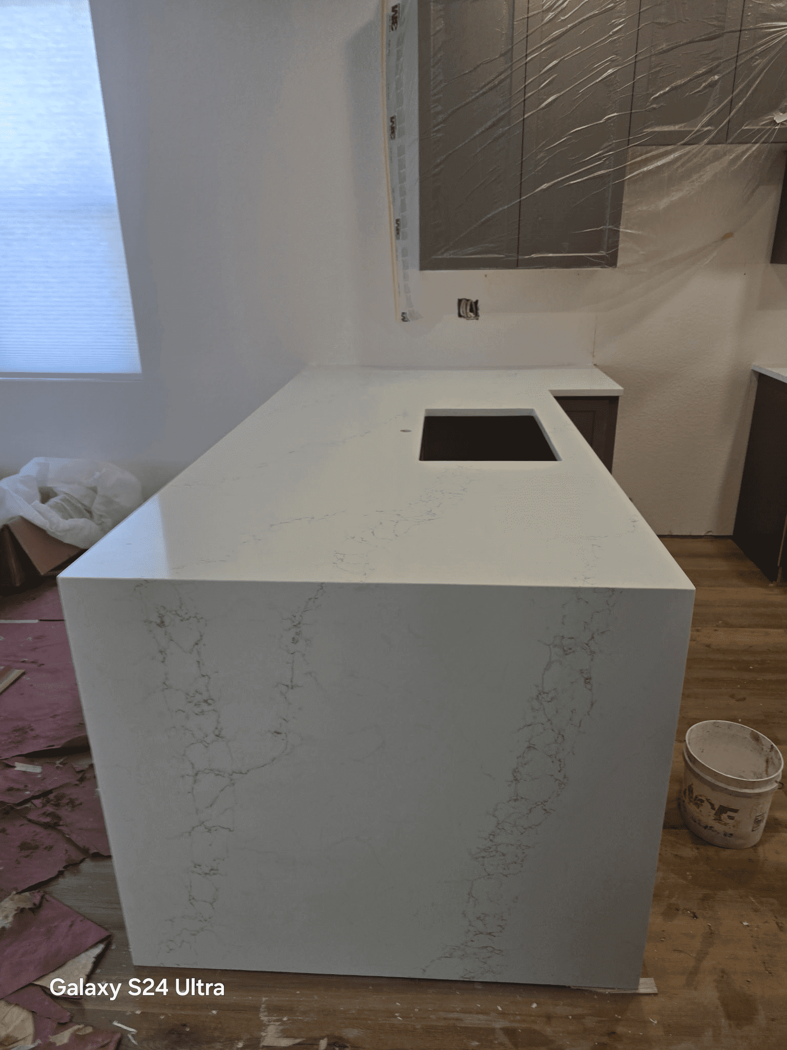 White kitchen island with marble pattern countertop.