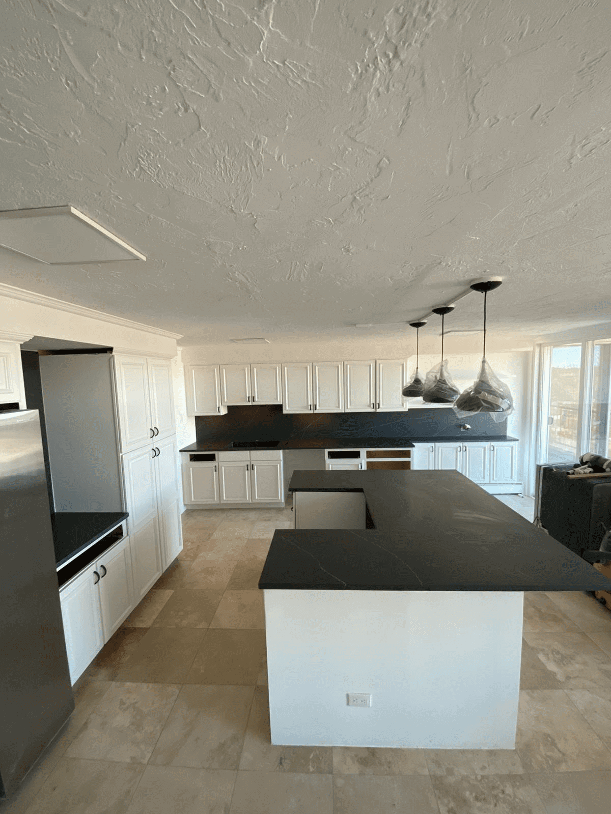 Modern kitchen with black countertops and island.