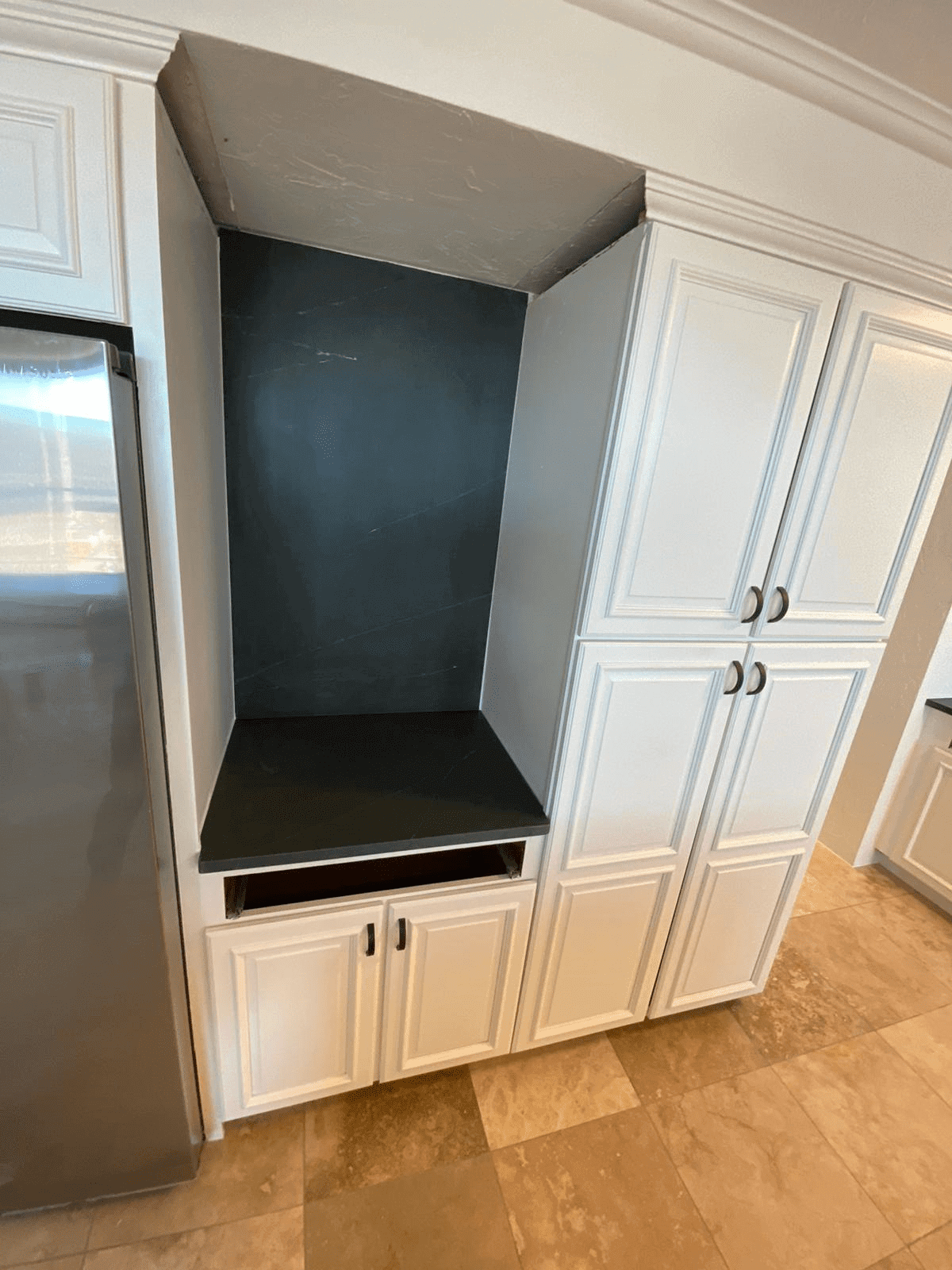 Empty kitchen alcove with white cabinets.