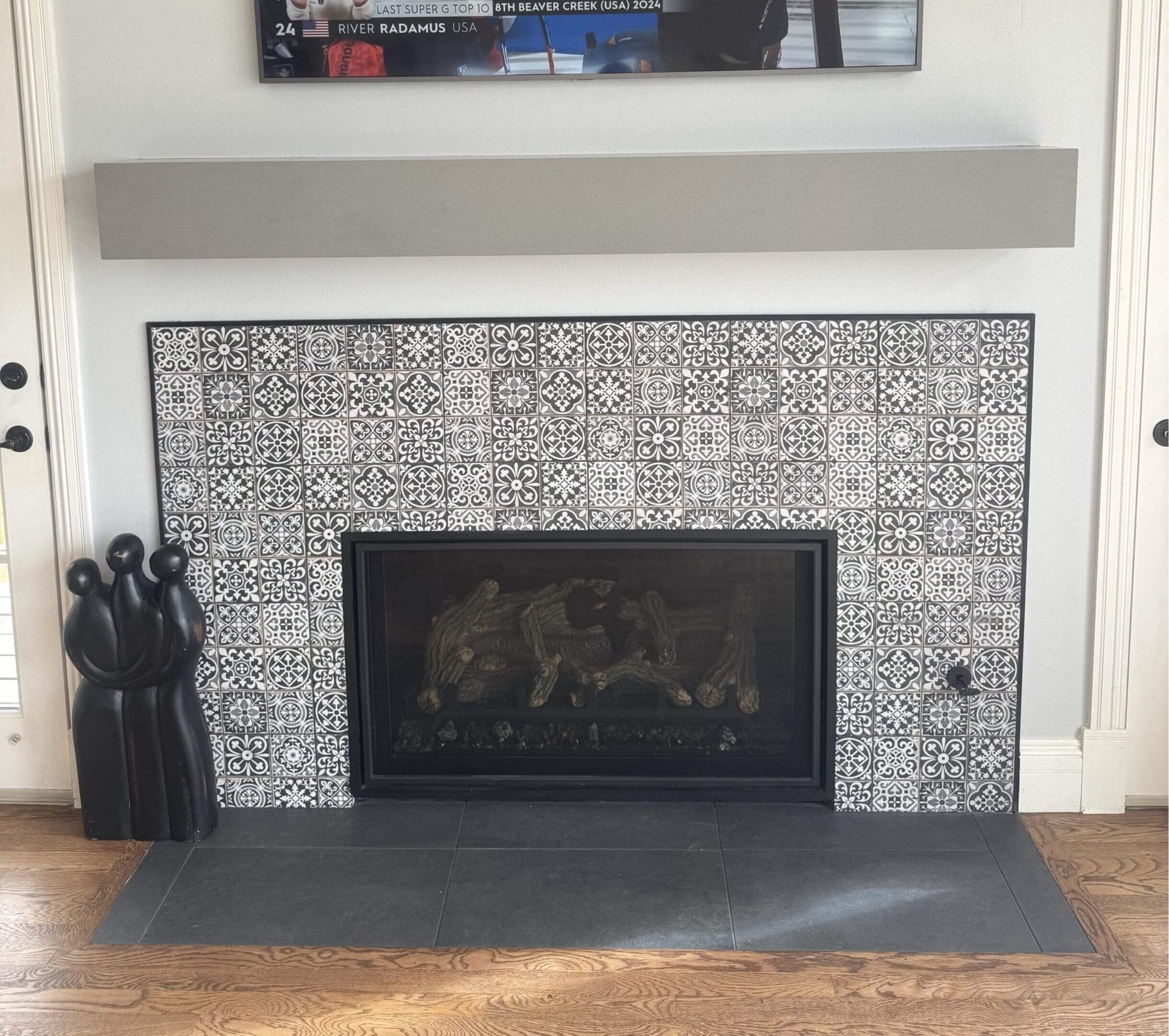 Tiled fireplace with black decorative sculpture nearby.